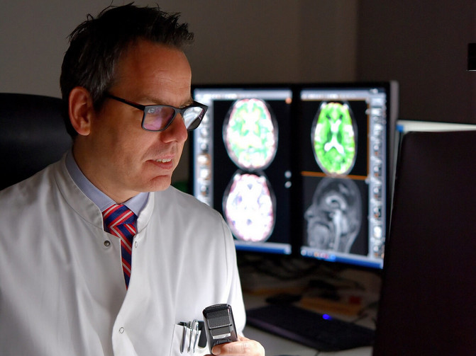 The image shows Prof. Dr. Carsten Lukas, Head of the Institute of Neuroradiology at St. Josef Hospital Bochum.