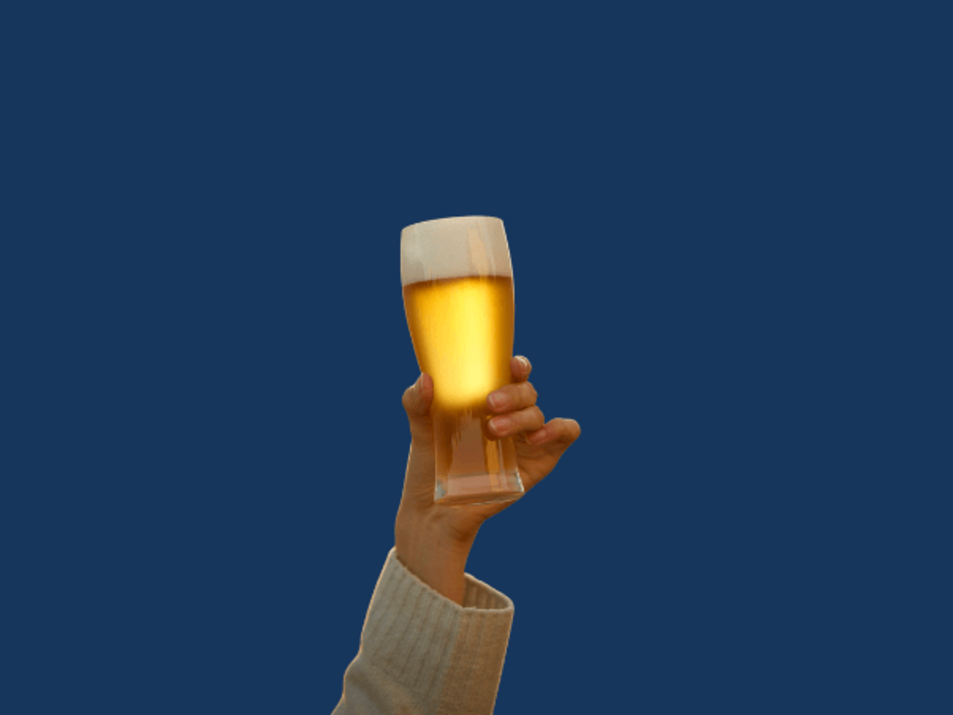Auf dem Bild ist im Vordergrund eine Hand zu sehen, die ein volles Bierglas in die Luft hebt. Der Hintergrund ist RUB-Blau. 