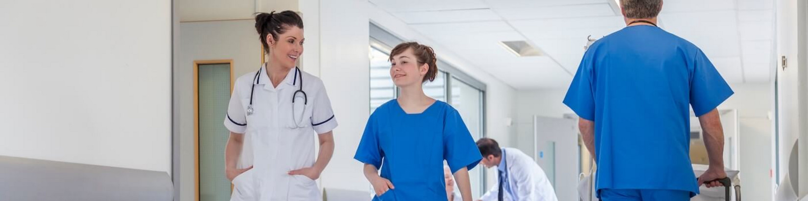 Mitarbeiter eines Krankenhauses gehen über den Gang