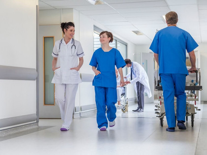 Mitarbeiter eines Krankenhauses gehen über den Gang